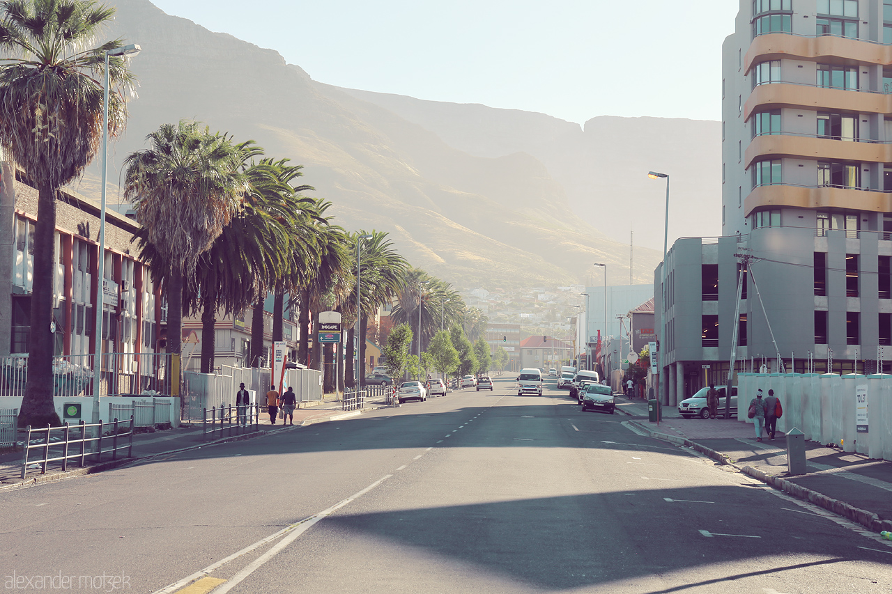 Foto von Morning light casts long shadows over Woodstock, Cape Town, as Table Mountain looms majestically in the backdrop.