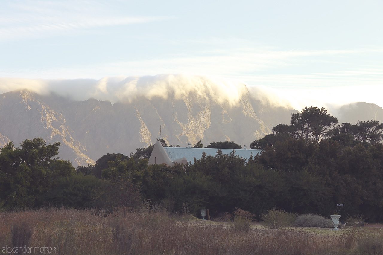 Foto von Morning mist drapes over lush greenery and mountains in Franschhoek, South Africa, creating a serene landscape of natural beauty.