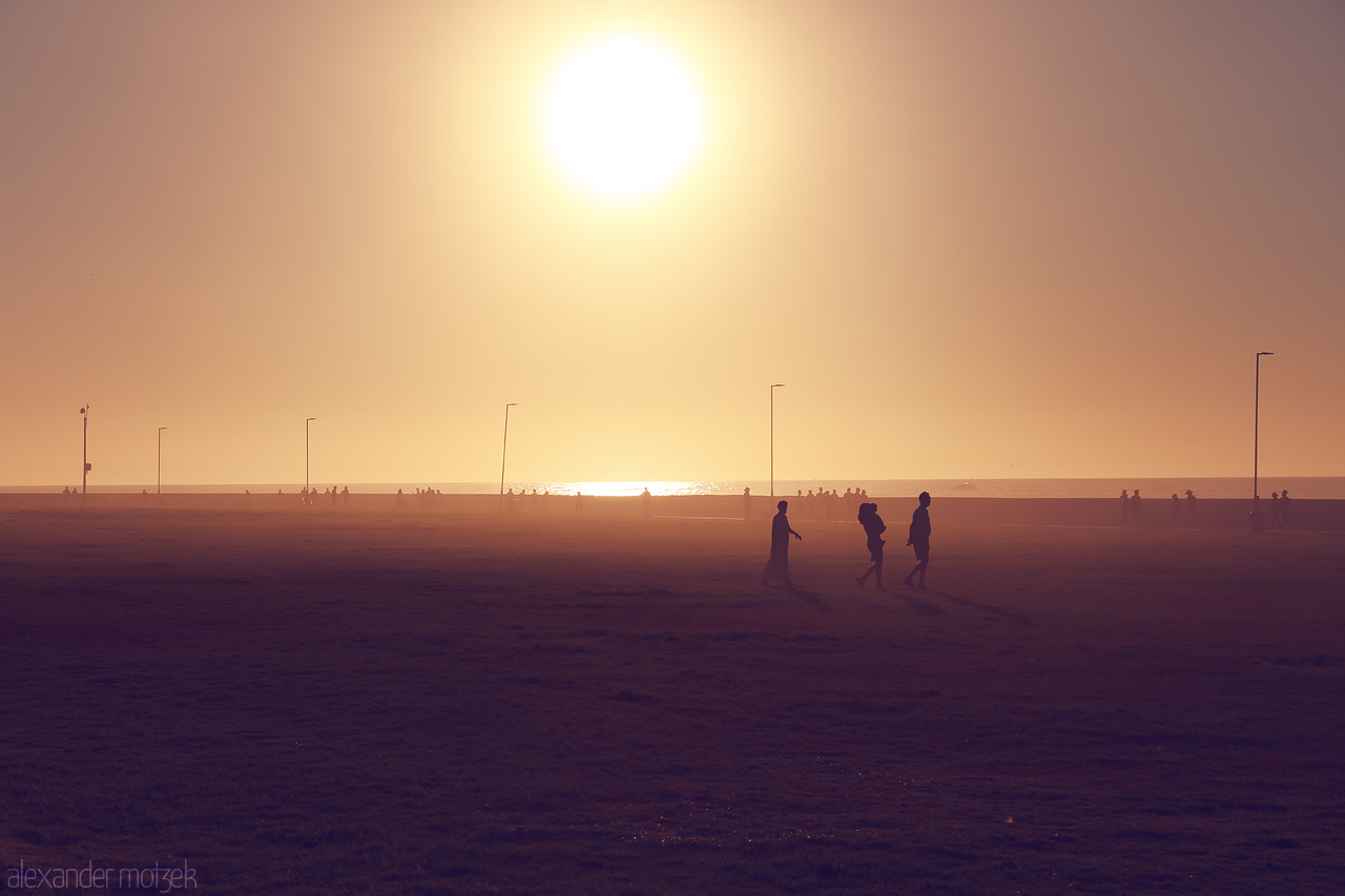 Foto von Silhouettes stroll under a golden Cape Town sun, basking in the glowing horizon and serene ocean backdrop.