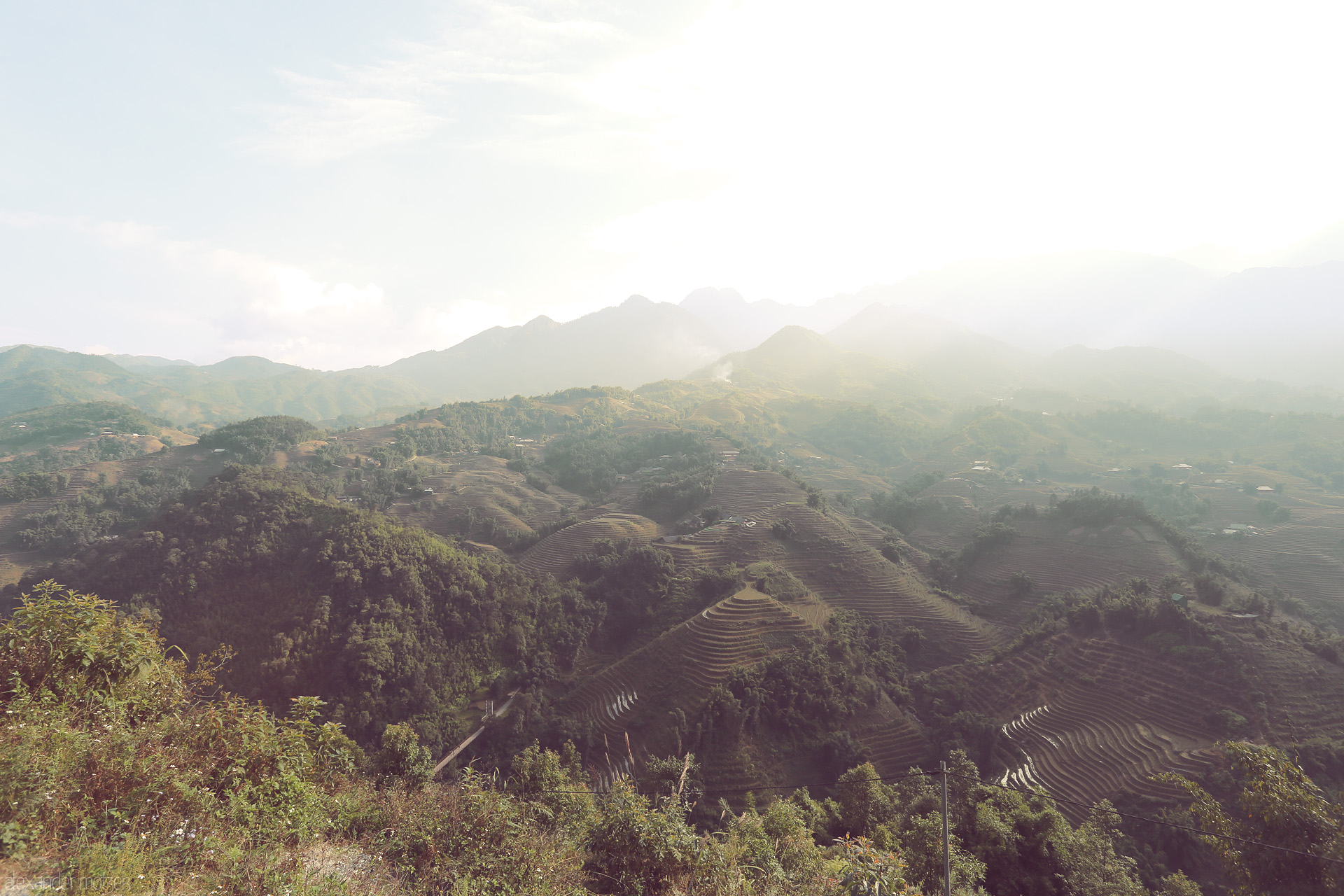 Foto von Sunlight bathes Sapa’s cascading rice terraces and misty mountains in a dreamlike, emerald glow—nature’s poetry in northern Vietnam.