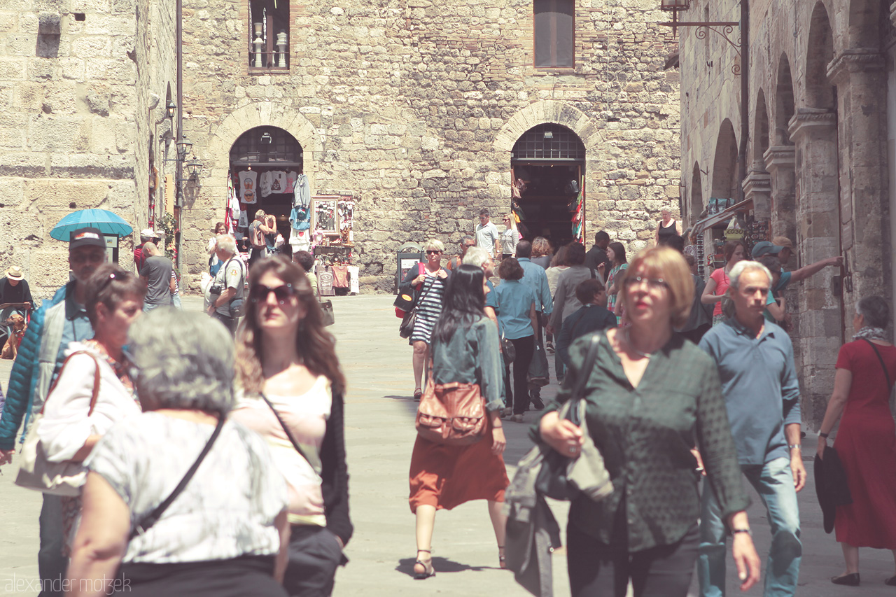 Foto von Bustling streets of Tuscany reflect timeless charm, with people immersed in a sunlit, historic ambiance.