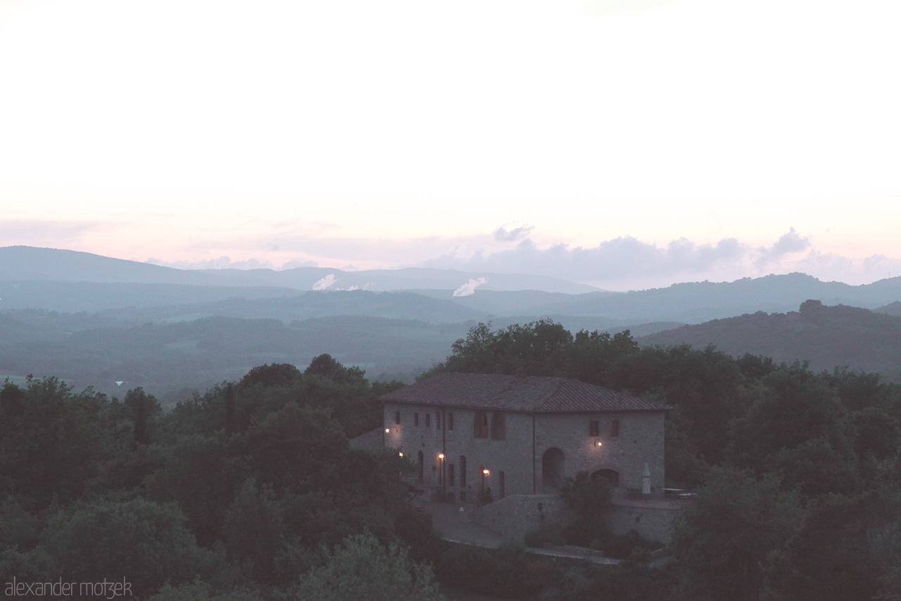 Foto von Gentle dusk over Tuscany's rolling hills and rustic villa in Pentolina, capturing serene Italian countryside charm.