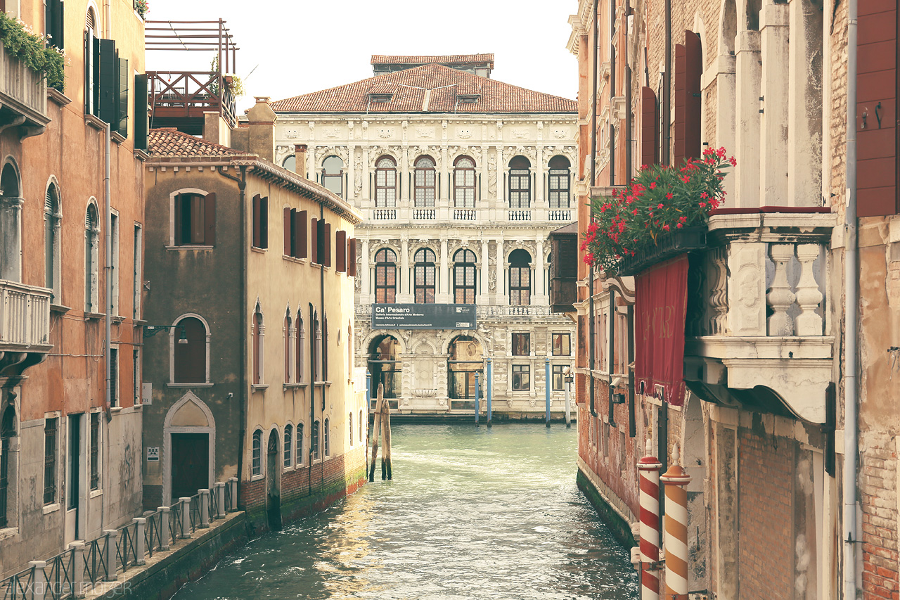 Foto von Charming canal flanked by historic Venetian architecture and a hint of flourishing flora.