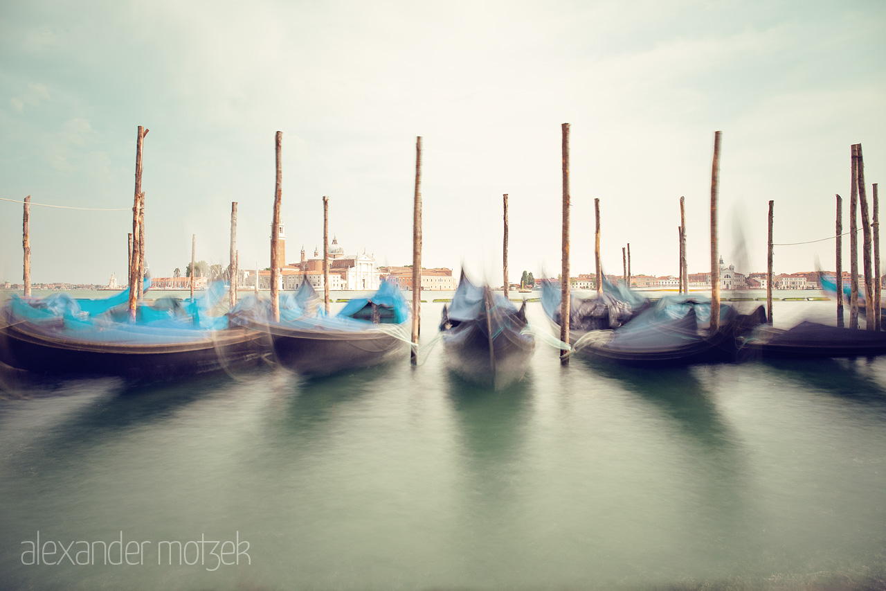 Foto von Long exposure of serene gondolas bobbing on the tranquil waters against a historic Venetian backdrop.