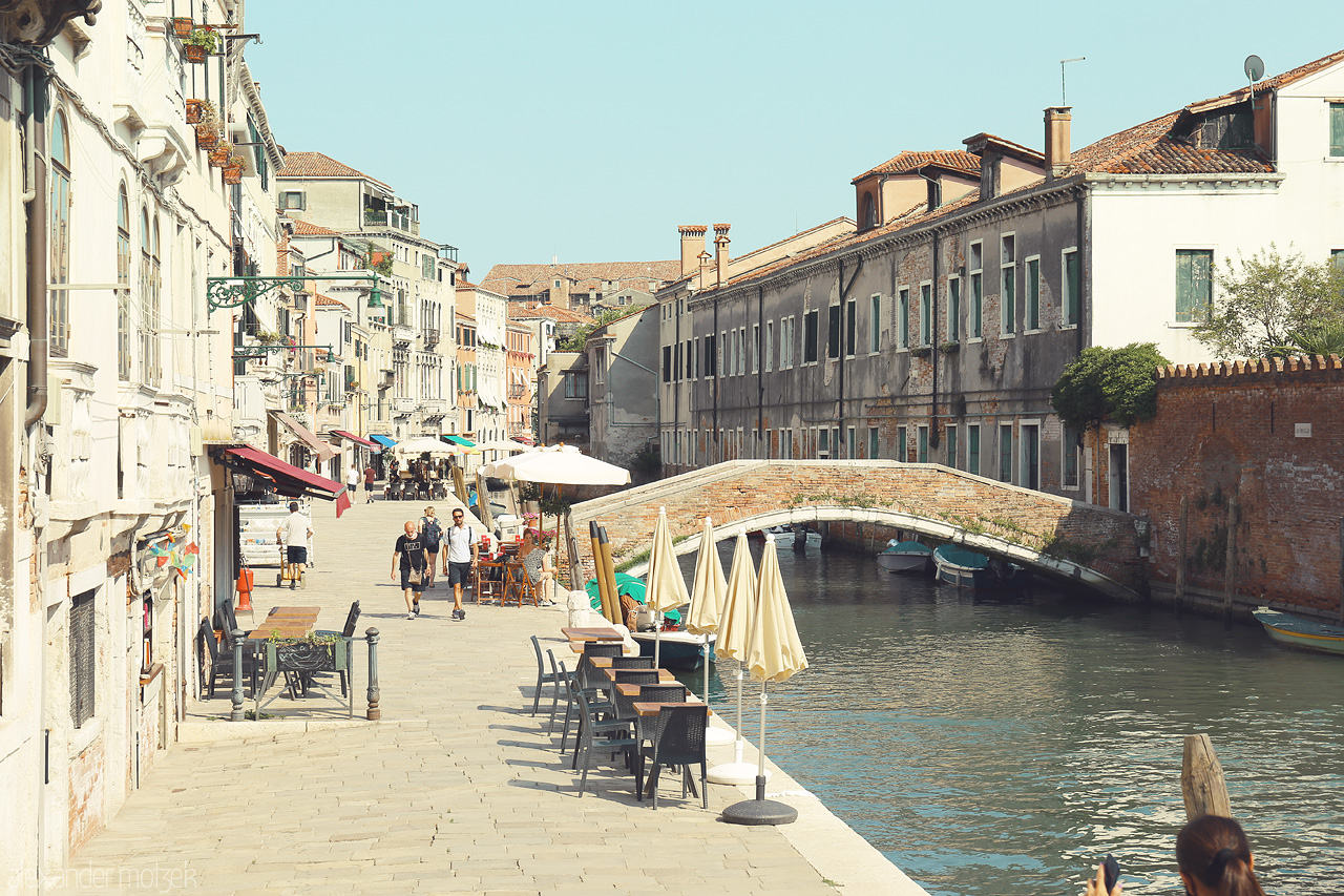 Foto von Sunny day in Venice with a quaint bridge and historic buildings lining a tranquil canal.
