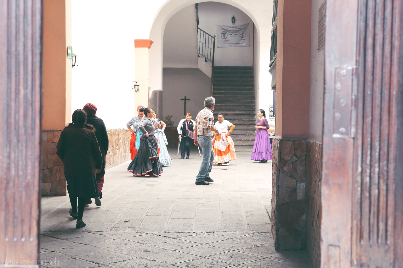 Puebla Pasos Foto von Vibrant folk dancers prepare to perform, showcasing Puebla's rich culture amid colonial architecture.