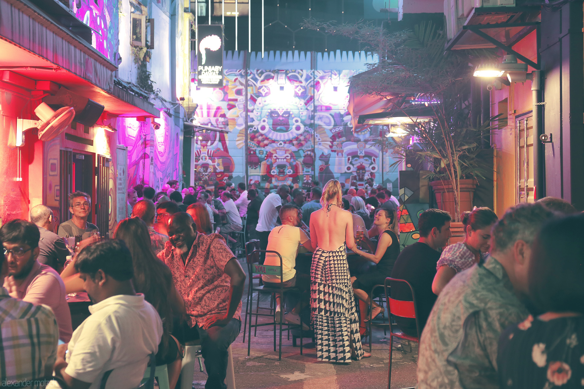 Foto von Vibrant nightlife in Singapore’s Kampong Glam, with neon-lit murals, eclectic crowds, and buzzing open-air cafes in a lively back alley.