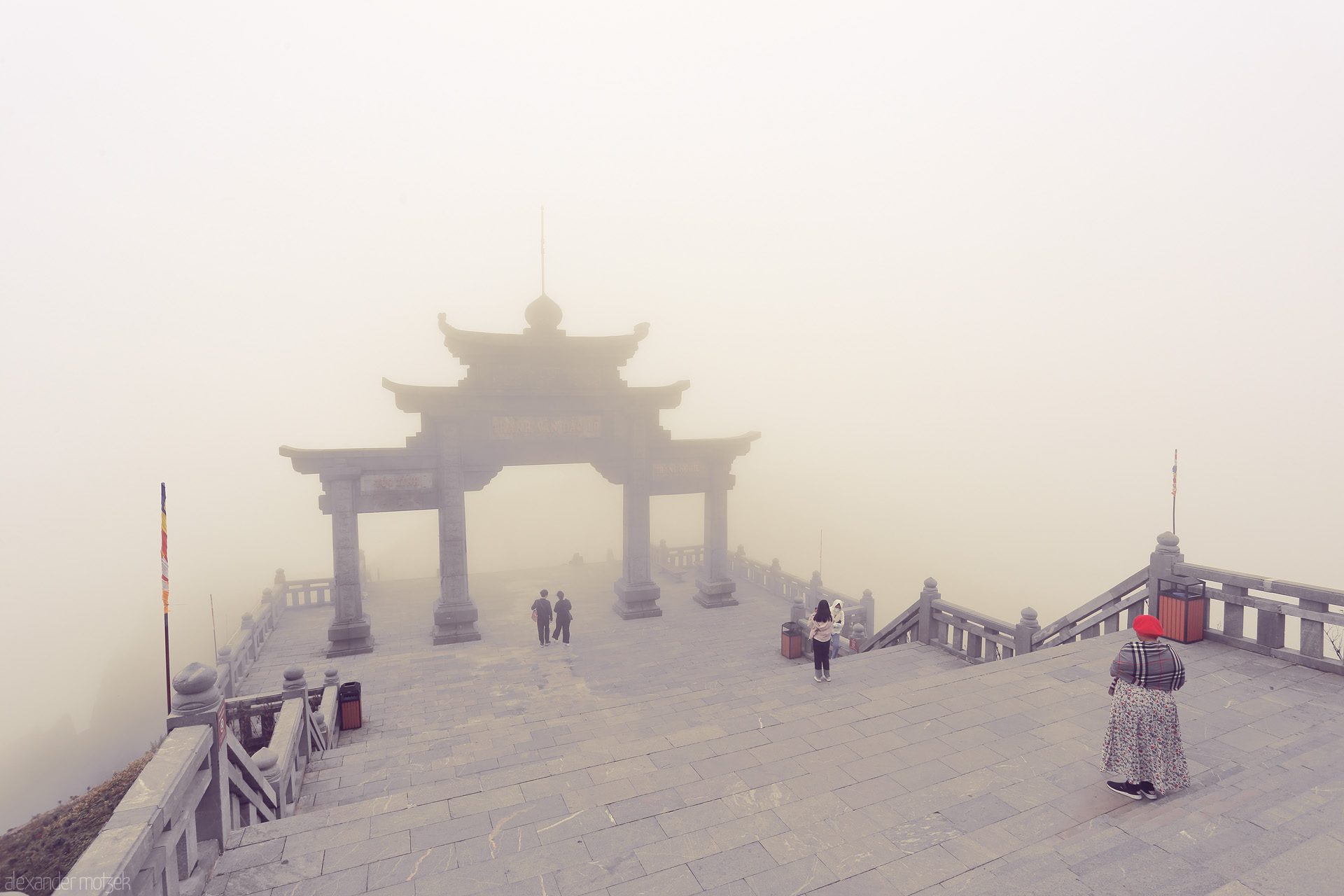 Mist Gateways of Fansipan Foto von Ancient stone gate on misty Fansipan, Sapa—travelers wander into a dreamlike sea of clouds atop Vietnam’s ‘Roof of Indochina’.