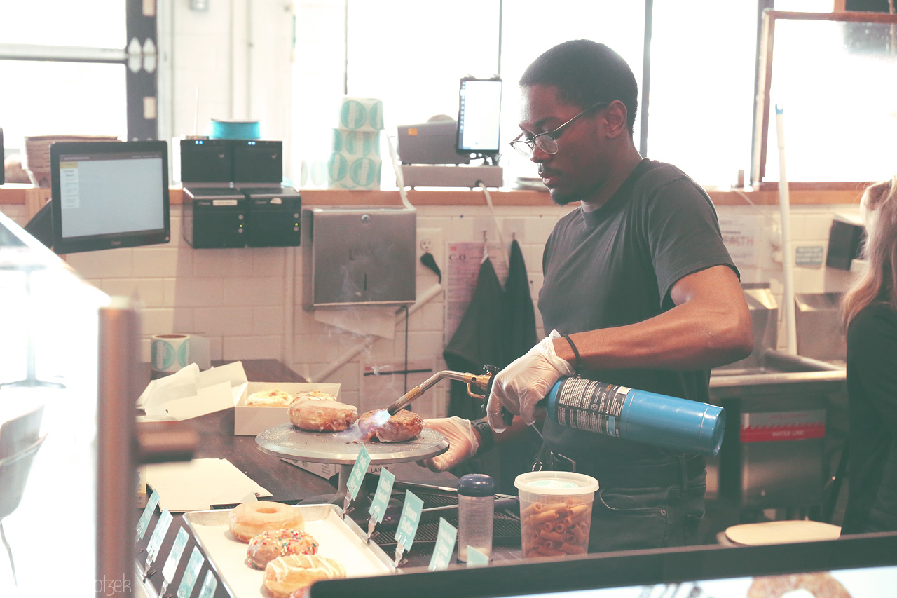 Foto von A chef skillfully torches gourmet donuts in a Washington, DC shop, blending culinary art with the city's vibrant flavors.