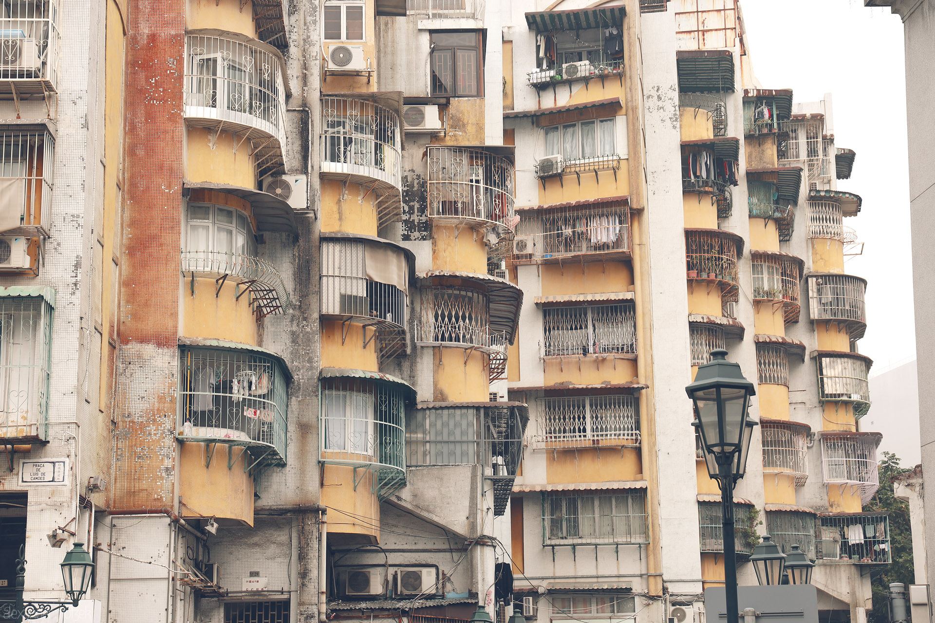 Foto von Weathered curved balconies and iron grilles near Praca de Luis de Camoes, Santo Antonio, Macau—urban textures in soft light.