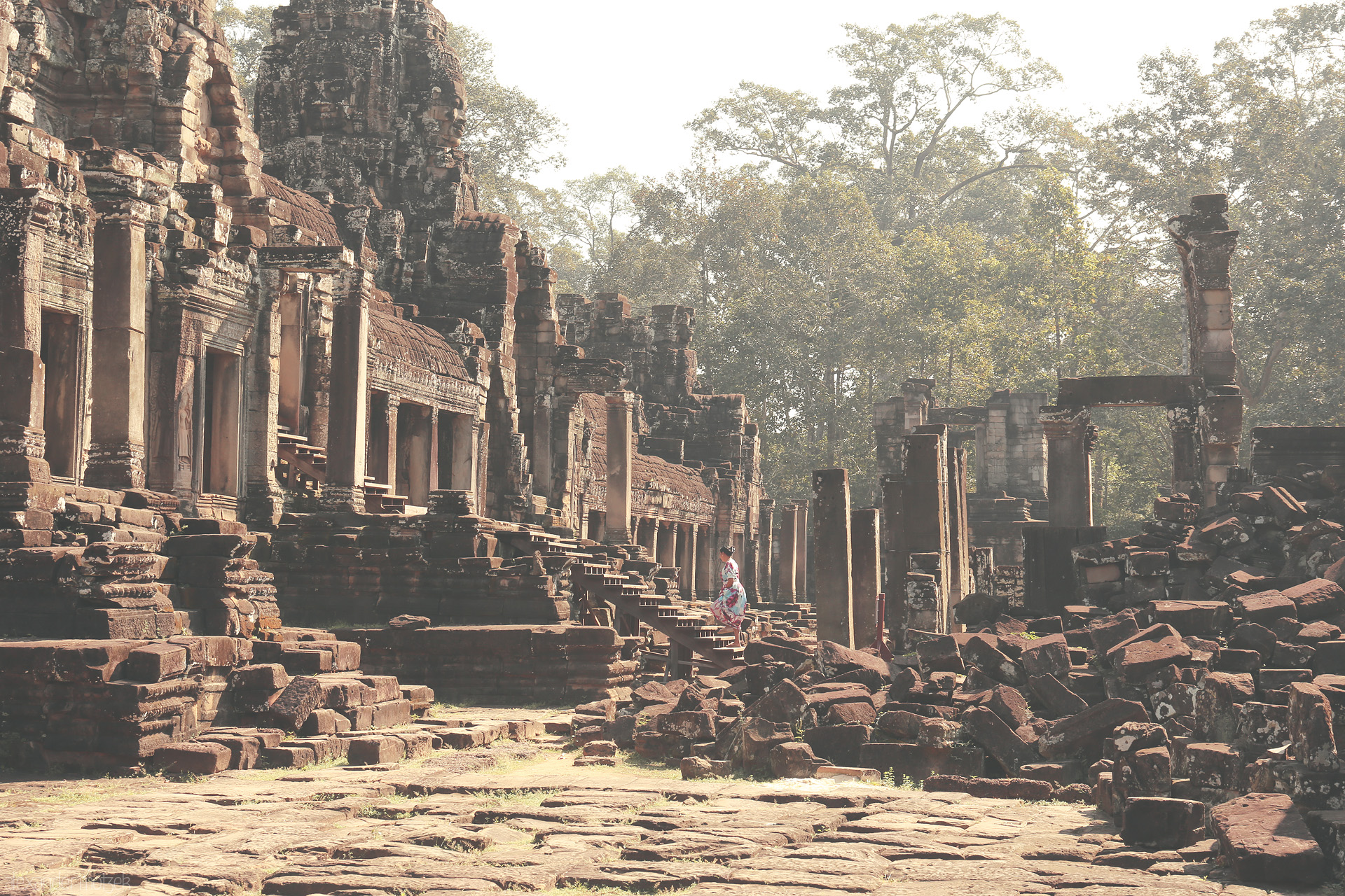 Foto von Whispers of ancient Angkor Wat: a lone wanderer dressed in color amid timeless Khmer stone and jungle light, Siem Reap, Cambodia.